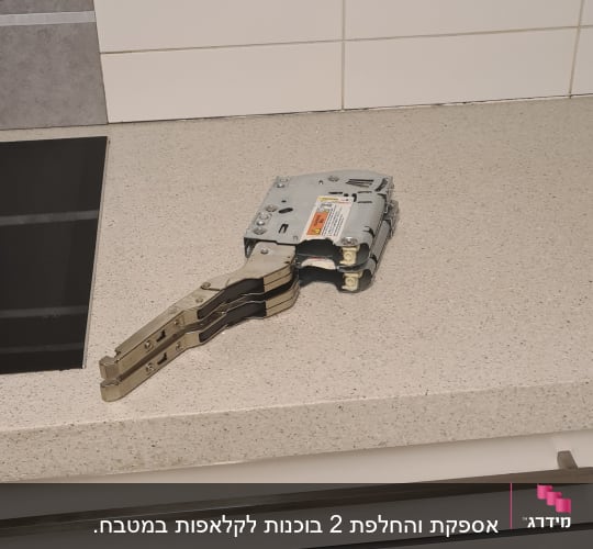 ציר מתכת על משטח מטבח ליד כיריים